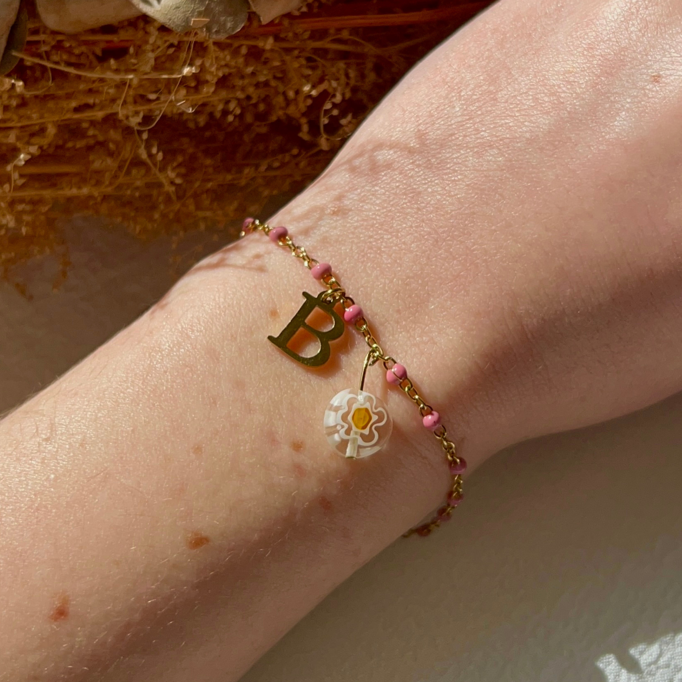 bracelet barbie doré personnalisable avec lettre et perle Millefiori, présenté ici avec la lettre B et perle rose