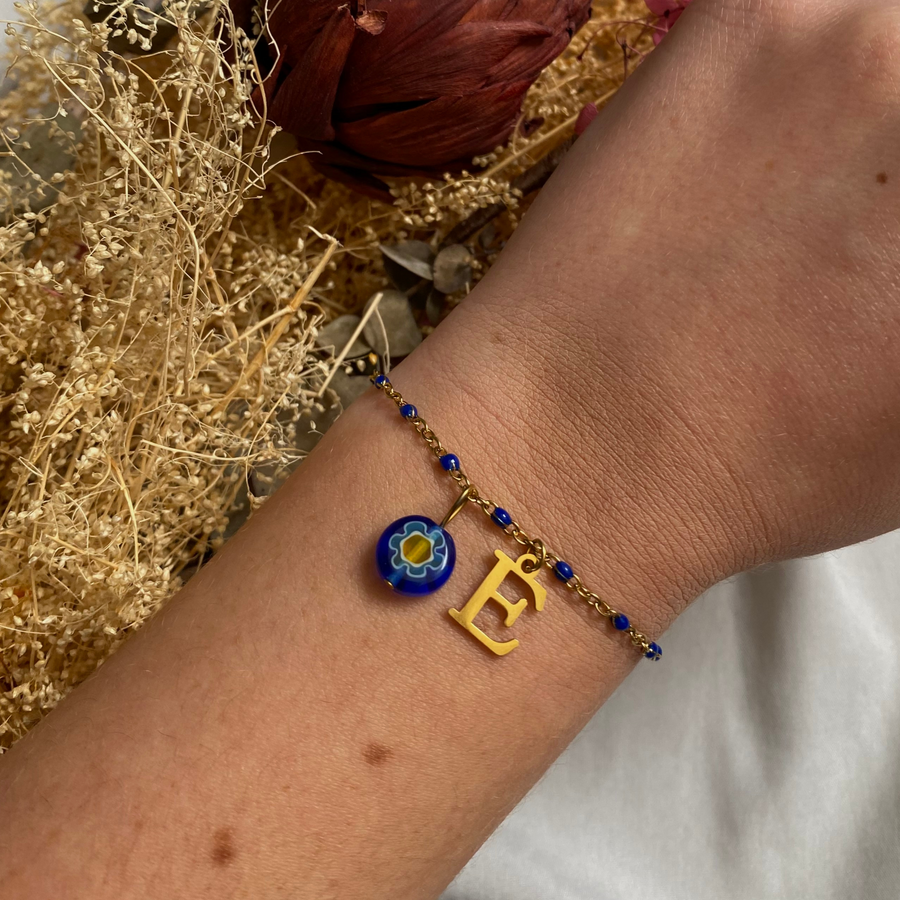 bracelet Émilie personnalisable avec lettre et perle Millefiori, présenté ici avec la lettre E et perle bleue