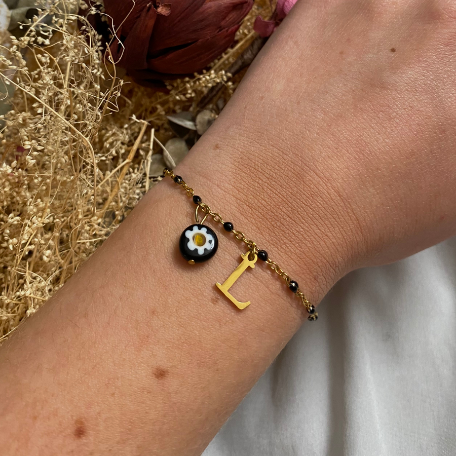 bracelet lizzie doré personnalisable avec lettre et perle Millefiori, présenté ici avec la lettre L et perle noire