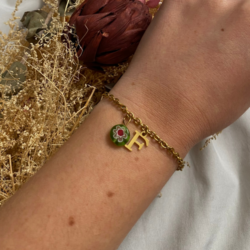 bracelet flavie personnalisable avec lettre et perle Millefiori, présenté ici avec la lettre F et perle verte